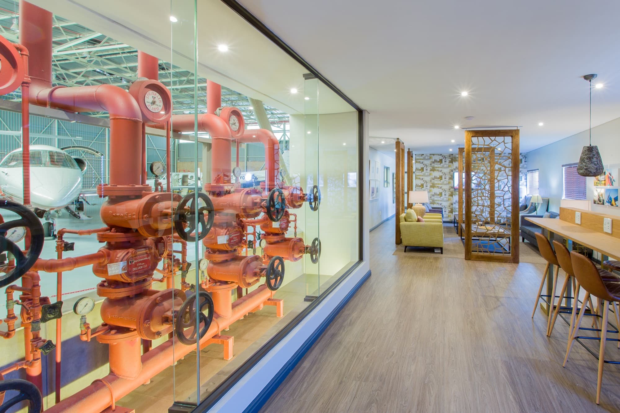 The Cape Town Advantage Lounge with its red industrial pipe wall seen through glass