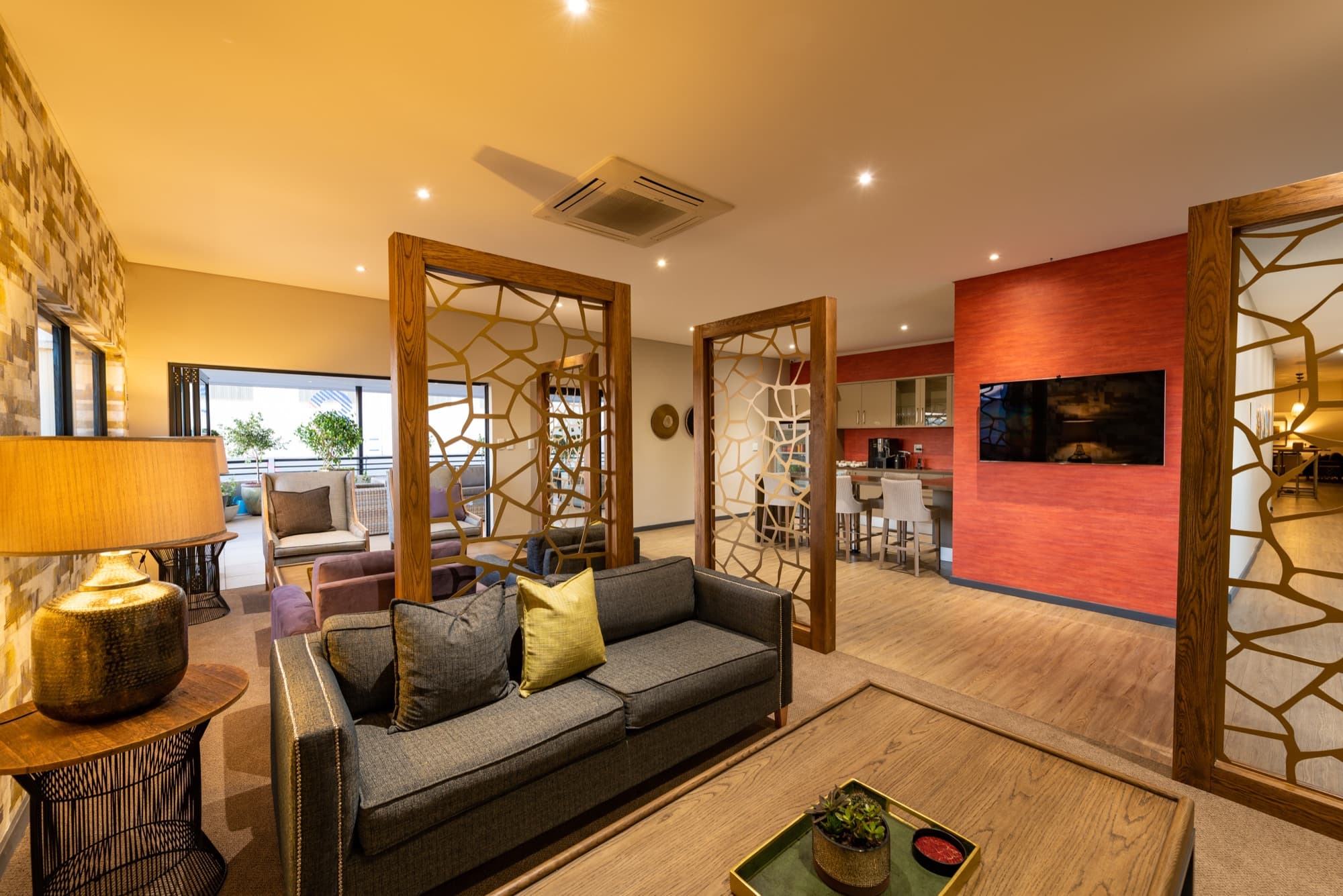Inside the AXIS Advantage Lounge at Lanseria, a wide warmly lit lounge with layered seating areas