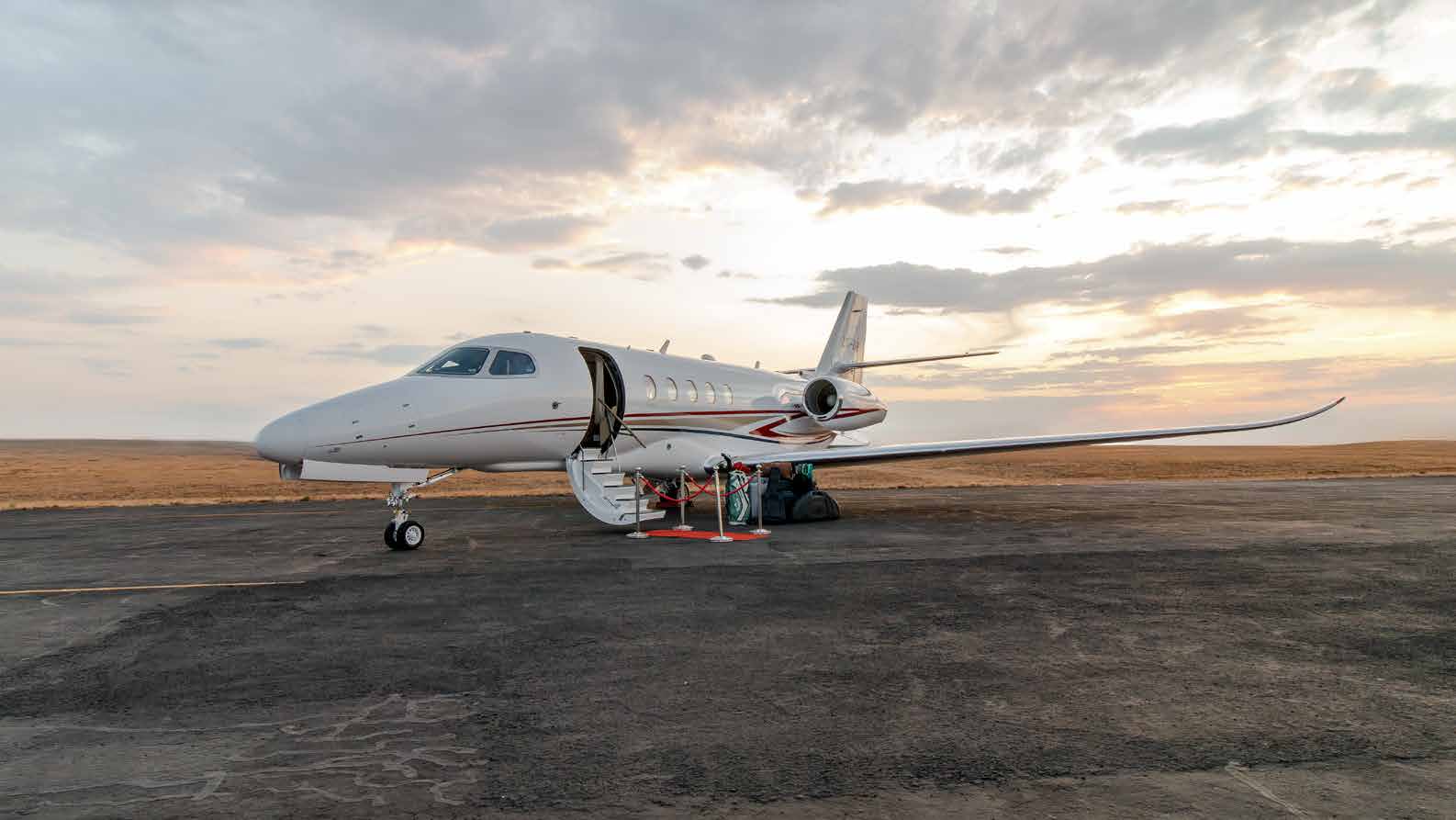 A private jet on a remote airfield at dusk, ready for departure